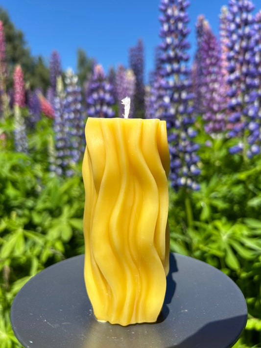 The Golden Flow Candle is a sculptural, hand-poured piece made from 100% pure New Zealand beeswax. Its flowing, organic shape is inspired by natural movement, making each candle completely unique.